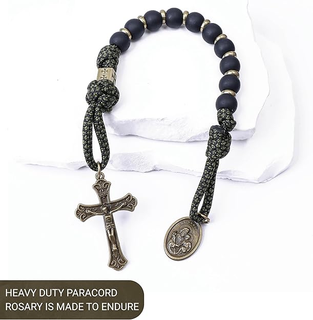 Heavy-duty paracord rosary with black beads and metal charms on a white background