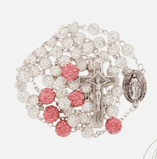 Rosary with pink and clear beads with Miraculous medal and Jesus cross on a white background