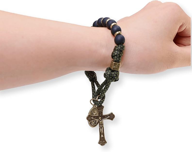 Bracelet with a cross pendant on a wrist against a white background
