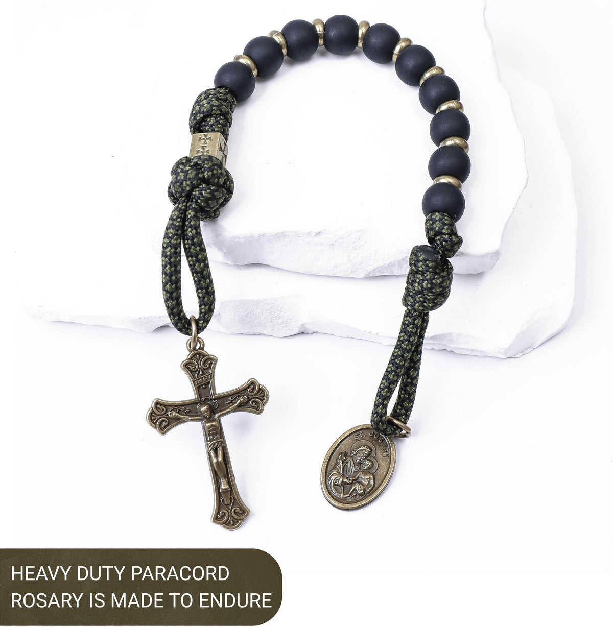 Heavy-duty paracord rosary with black beads and metal charms on a white background