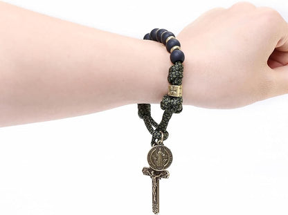 Rosary with beads and a cross on a wrist against a white background