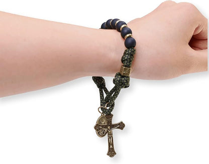 Bracelet with a cross pendant on a wrist against a white background