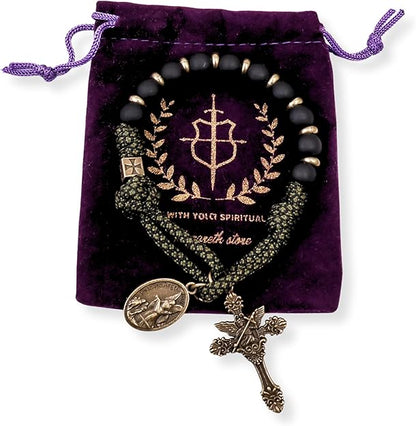 Black beaded one decade Rosary with gold accents and charms on a purple velvet bag